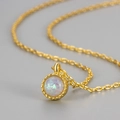 Elegante collana dorata con pendente in opale rotondo e bordo rifinito in stile miligrana - Bianco Opale Oro