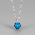 Elegante collana in argento con ciondolo in opale blu tondo e castone testurizzato - Blu Opale Argento
