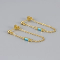 Detailed shot of gold chain earrings featuring elegant rectangular blue stones on a grey surface - Copper / Gold / Turquoise Blue Zircon