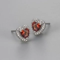 Close-up of heart-shaped red zircon earrings with white stone halo in silver base - Red Zircon