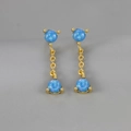 Dettaglio di orecchini a nappa dorati con pendenti sferici in opale blu vibrante - Oro con Opale Blu