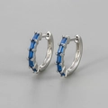 Detailed macro view of silver huggie earrings with baguette cut deep blue zircon stones - Silver/Royal Blue Zirconia