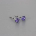 Close-up of classic four-prong purple round-cut zircon stud earrings in silver finish - 5mm / Purple