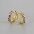 Detailed close-up of golden huggie earrings set with rectangular purple zircon stones - Gold / Purple Zirconia