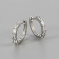 Close-up of silver huggie hoop earrings with baguette-cut sparkling cubic zirconia stones - Silver/White Zircon