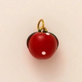 Macro view of a red apple charm with gold ring and white dots for DIY keychains - Tomato