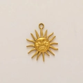 Detalle del colgante de sol bañado en oro de 18K mate con rayos y texturas metálicas finas - Sol