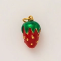 Close-up of strawberry pendant with red enamel and gold-plated details for DIY jewelry - Strawberry