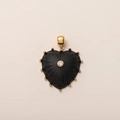 Détail macro d'un pendentif cœur noir plaqué or 14K avec un zircon central et perles dorées - Style Cœur en Nacre Noire