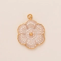 Close-up of golden flower charm with cream enamel petals and intricate vintage details - Small White Flower