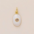 Macro view of oval gold pendant with white enamel inlay and pink faceted gemstone center - October Birthstone Pendant