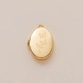 Golden oval locket pendant with engraved butterfly detail in a minimalist studio setting - Butterfly Engraved Locket Pendant