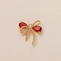 Golden bow pendant with pear-shaped red gemstones and a small central diamond accent - Red Bow Pendant