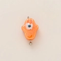 Macro-opname van oranje keramische Hamsa-hanger met boze oog en 18K vergulde haak - Geel Boze Oog