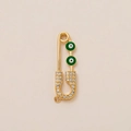 Macro shot of gold-plated safety pin pendant with green evil eye and white zircon stones - Green Eye Paperclip Pendant
