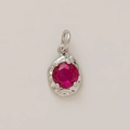 Detailed close-up of a round ruby-red gemstone set in a textured gold-plated pendant - July Birthstone