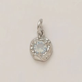 Detailed macro view of a gold-plated circular pendant featuring a faceted crystal stone - October Birthstone