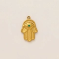 Detail view of a 18K gold Hamsa pendant with an engraved eye and a green zircon stone - Hamsa Hand Pendant
