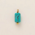 Macro view of a cylindrical turquoise pendant with gold-plated wire-wrapped ring detail - Turquoise Cylinder Pendant