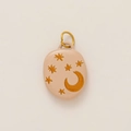 Détail d'un pendentif ovale abricot avec des motifs de lune et d'étoiles dorés et anneau - Style Étoile et Lune Ovale