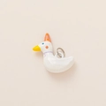 Close-up of a white ceramic duck pendant wearing a polka dot party hat and a purple neck tie - White Goose Pendant