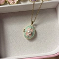 Vintage locket necklace with pale green enamel, pink floral pattern, and central pearl - Green Pearl Locket