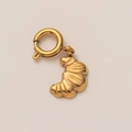 Detailopname van een 18K vergulde croissant hanger met gepolijste metalen texturen - Gouden Croissant Stijl Hanger