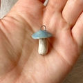 Detailansicht eines handgefertigten blauen Pilzanhängers mit natürlicher Glasur in der Hand - Nr. 19 Blauer Pilz Anhänger Ohne Kette