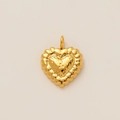 Close-up of golden heart pendant with hammered texture and 18k gold plating details - Heart