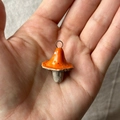 Handgefertigter orangefarbener Keramik-Pilzanhänger mit 18K Vergoldung auf weichem Stoffhintergrund - Nr. 1 Oranger Pilz Anhänger Ohne Kette