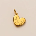 Detalle macro de un colgante de corazón dorado con un intrincado diseño de alas grabadas - Colgante Corazón Alas de Ángel No.5