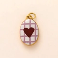 Detailed macro view of an oval golden pendant featuring purple checkered and red velvet heart - Checkerboard Heart Pendant