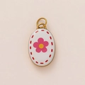 Detail of 18K gold plated oval pendant featuring a white enamel daisy flower design - White Small Pink Flower Pendant