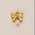 Primer plano de colgante de lazo dorado con perla blanca para joyería artesanal - Mariposa de Perlas