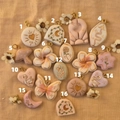 Flat lay of 16 assorted floral and animal patterned pendant charms for DIY jewelry making - 1 White Luminous Heart