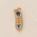 Vue détaillée d'un pendentif en forme de basket bicolore or et argent aux finitions précises - Chaussure