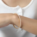 Elastisches vergoldetes Armband mit runden milchweißen Edelsteinen im geometrischen Design - Weißer Zirkonia Gold
