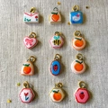 Set of 12 hand-painted charm pendants with fruit and animal motifs on golden rings - Envelope Pendant