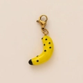 Makro-Detail eines 18K vergoldeten Bananen-Anhängers mit einem Karabinerverschluss - Bananen Anhänger
