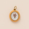 Dettaglio macro di un ciondolo tondo vintage con fiore rosso e anello oro 18K - Pendaglio Girasole Sfumato