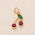Primer plano del colgante de cereza dorada con cristales rojos y piedra marquesa verde - Estilo Cereza