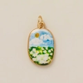 Macro shot of oval gold pendant featuring a miniature daisy field with sun and blue sky - Flower Field Pendant