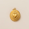 Macro shot of gold oval pendant with embossed sacred heart and cross detail - Oval Sacred Heart Pendant