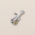 Dettaglio macro del ciondolo a chitarra con farfalla in smalto colorato e fiori - Stile Violino