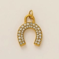 Macro shot of gold-plated horseshoe pendant with parallel rows of inlaid crystals - Horseshoe Pendant