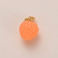 Macro detail van een feloranje framboos hanger met een gouden metalen lus - Framboos