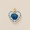 Macro detail of heart-shaped ceramic pendant with blue scallop print and gold ring - Heart Shell