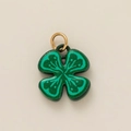 Close-up of green clover pendant with glitter coating and gold metal hanging loop - Four-Leaf Clover
