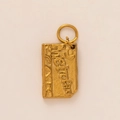 Macro detail of Metropolis engraved gold rectangular pendant with frosted metal texture - Postcard Pendant