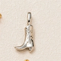 Macro shot of a silver cowboy boot pendant with embossed patterns and polished finish - Silver Boot Pendant